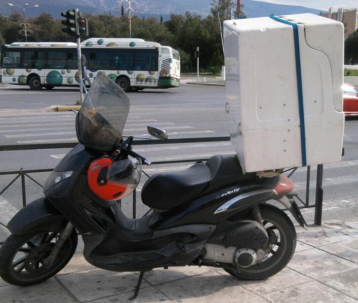 Μηχανάκι διανομής της Aetos Courier με κουτί μεταφοράς